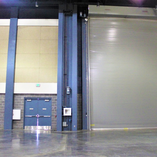 Roll up door in Exhibit Hall B with emergency exit door located on left side