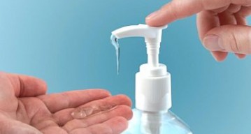 Hand pumping hand sanitizer
