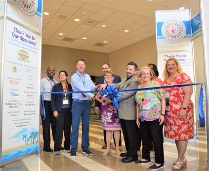 Group of people blue ribbon cutting for entry of exhibit hall