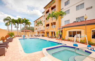 Courtyard Marriott WPB Airport pool area with yellow building