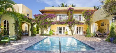 Yellow Apartments covered with vines and vegetation and an open pool area