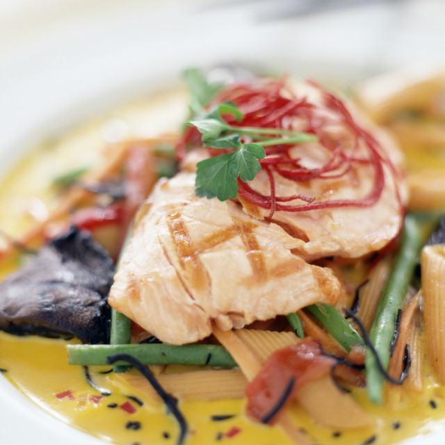 Food Photo of grilled Salmon on top of penne pasta and a orange sauce with mixed vegetables